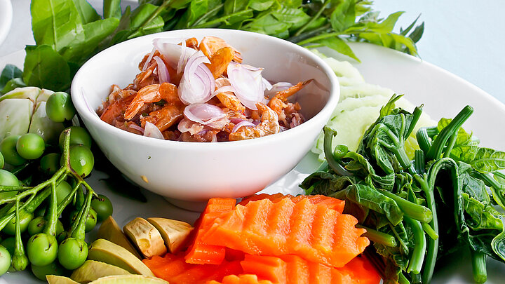 Zdjęcie miski z potrawą oraz warzyw dookoła niej.