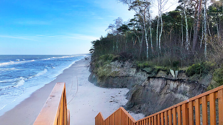 Zdjęcie drewnanych schodów prowadzących na plażę.